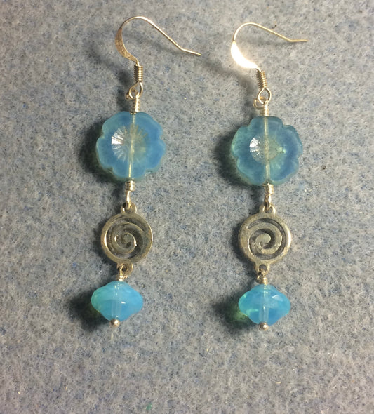 Turquoise Czech glass pansy bead earrings adorned with silver swirly connectors and translucent turquoise Czech glass Saturn beads.