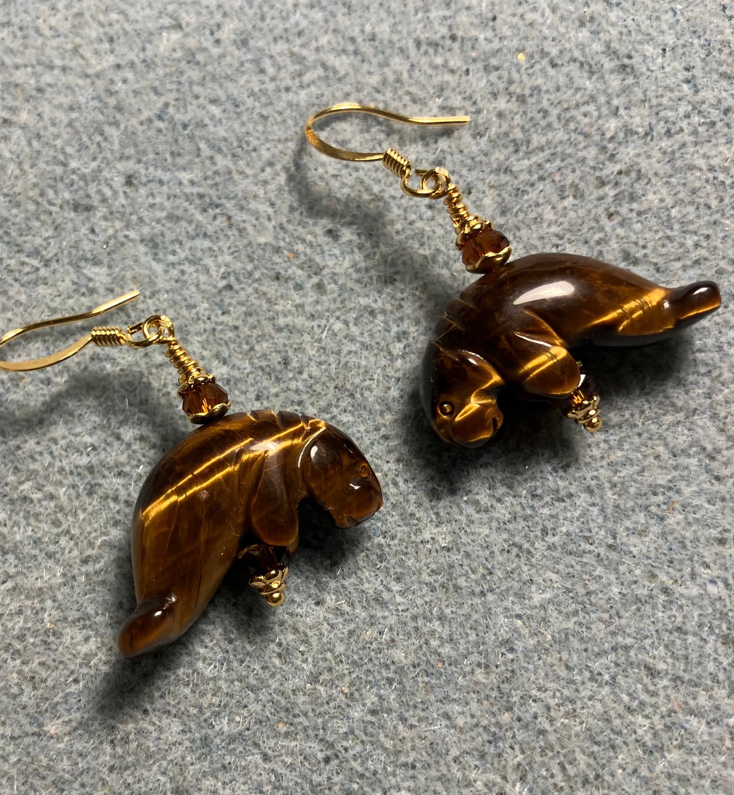 Tigereye gemstone manatee bead earrings adorned with dark amber Chinese crystal beads.