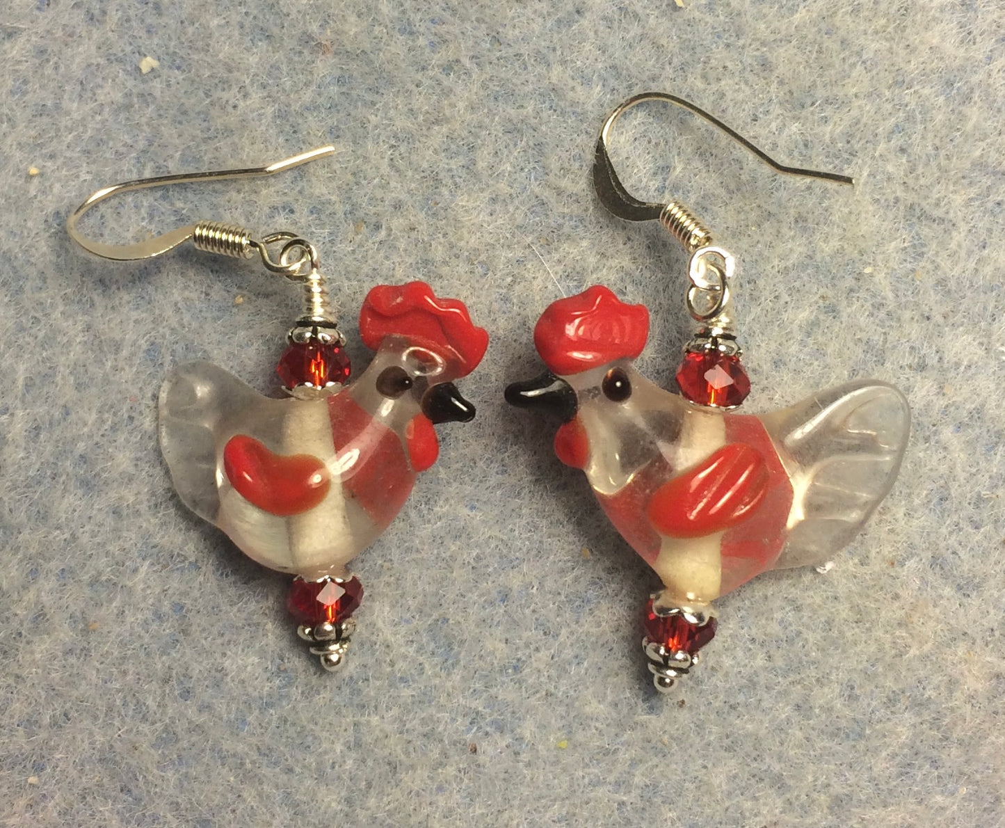 Clear and red lamp work chicken bead earrings adorned with red Chinese crystal beads.