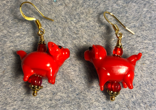 Opaque red lamp work pig bead earrings adorned with red Czech glass beads.
