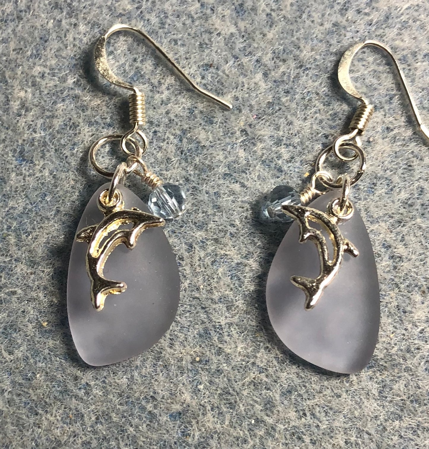 Small light blue sea glass pendant bead earrings adorned with small silver dolphin charms and small light blue Chinese crystal beads.