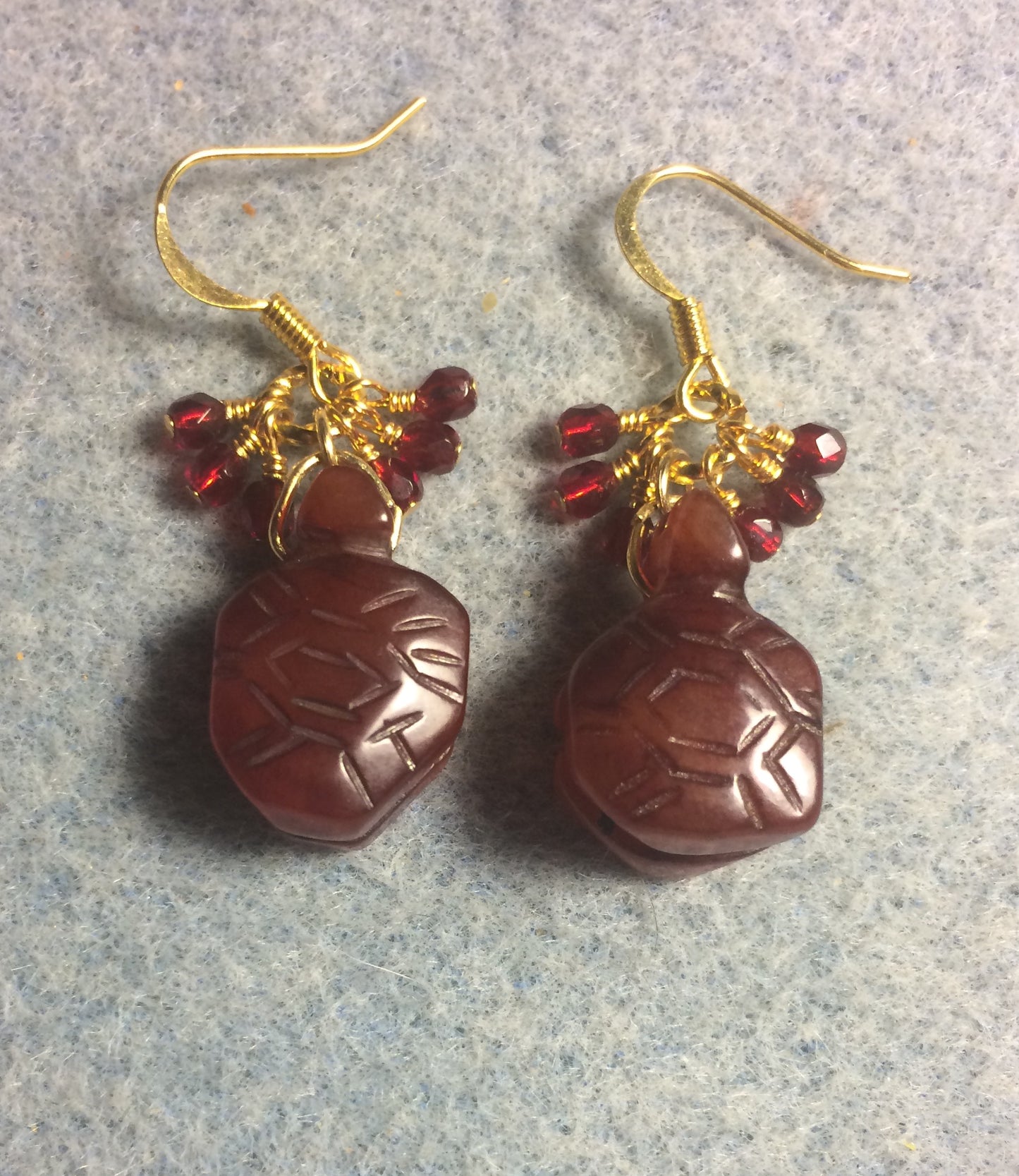 Carved dark red brown agate gemstone turtle bead earrings adorned with small dark red Czech glass beads.