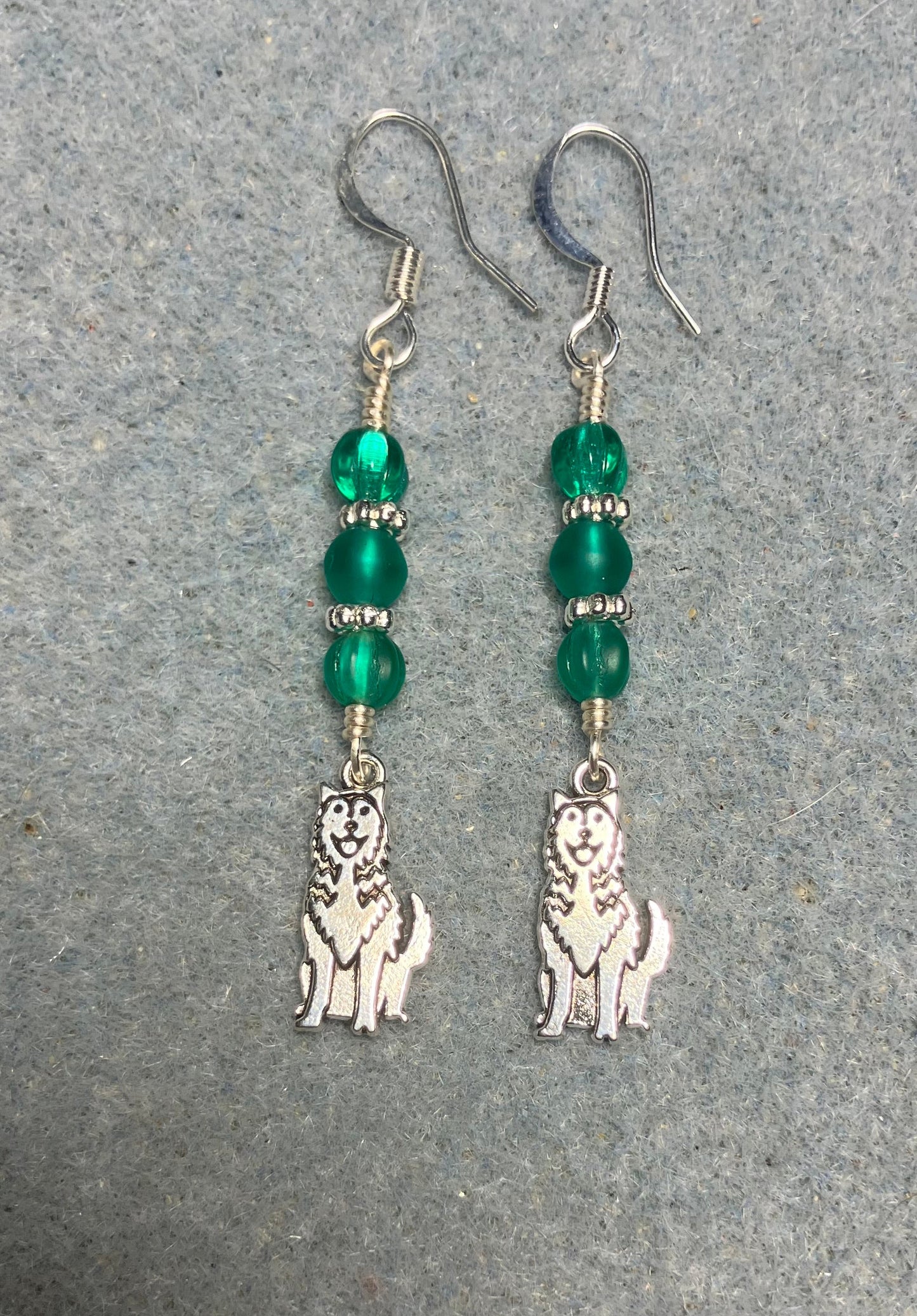 Small silver husky charm earrings adorned with small teal Czech glass beads.