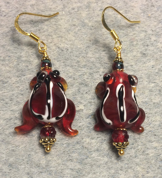 Translucent dark red lamp work striped frog bead earrings adorned with dark red Czech glass beads.