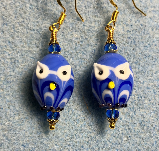 Bright blue lamp work owl bead earrings adorned with bright blue Chinese crystal beads.