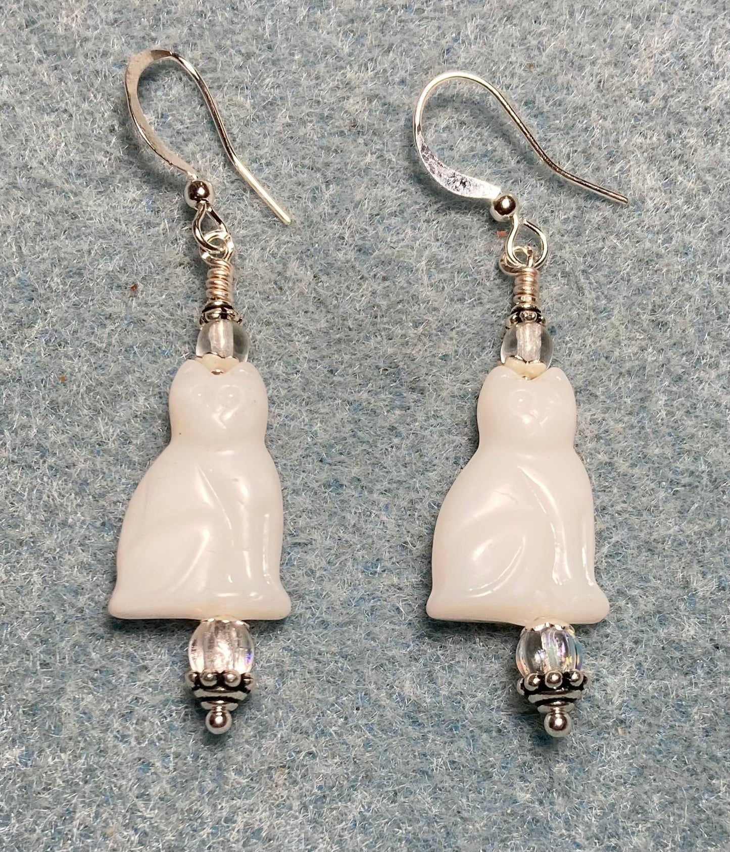 Opaque shiny white Czech glass cat bead earrings adorned with clear Czech glass beads.