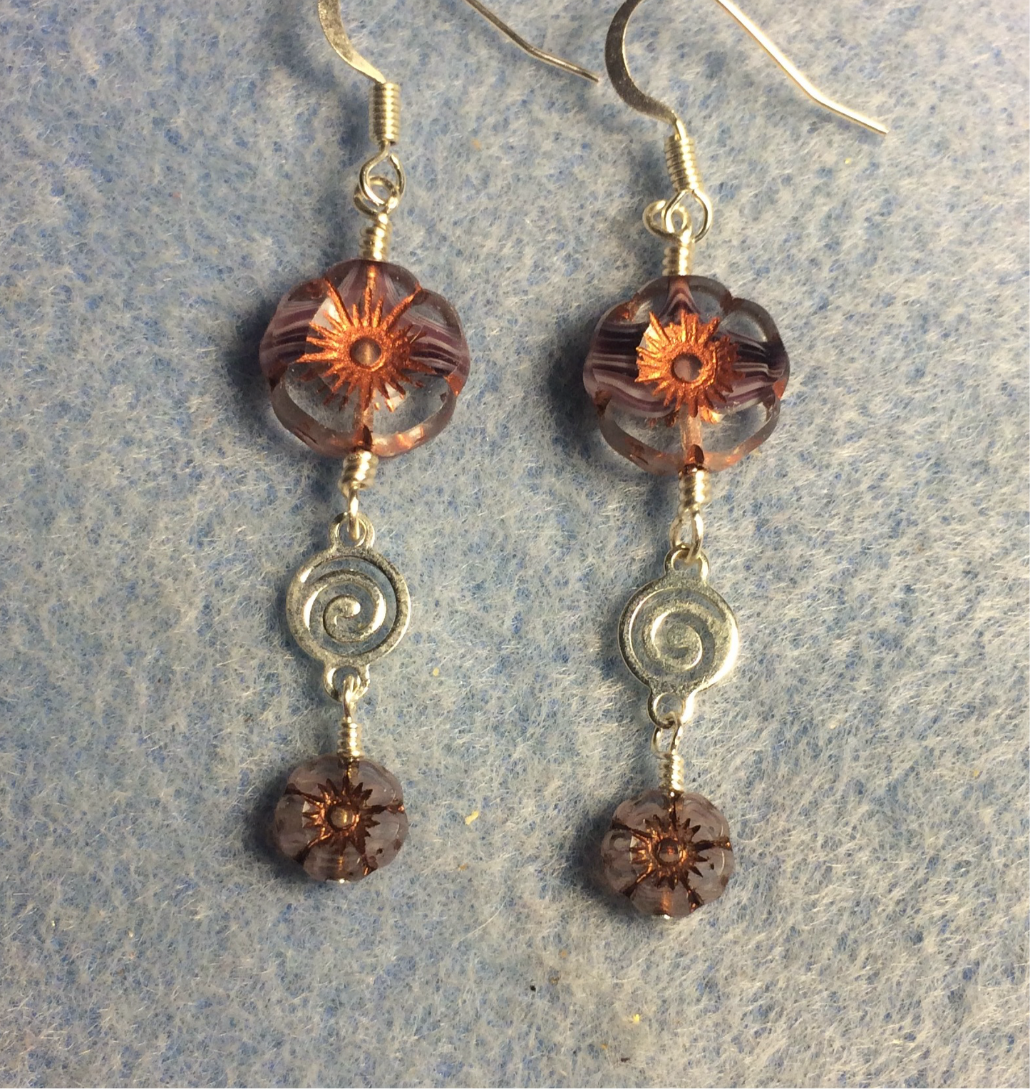 Purple and copper Czech glass pansy bead earrings adorned with silver swirly connectors and tiny purple and copper Czech glass pansy beads.