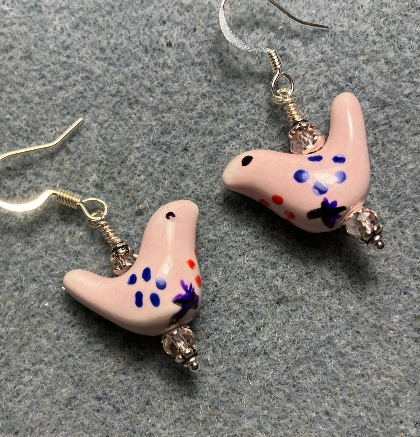 Small light pink, blue, and purple ceramic bird bead earrings adorned with light pink Chinese crystal beads.