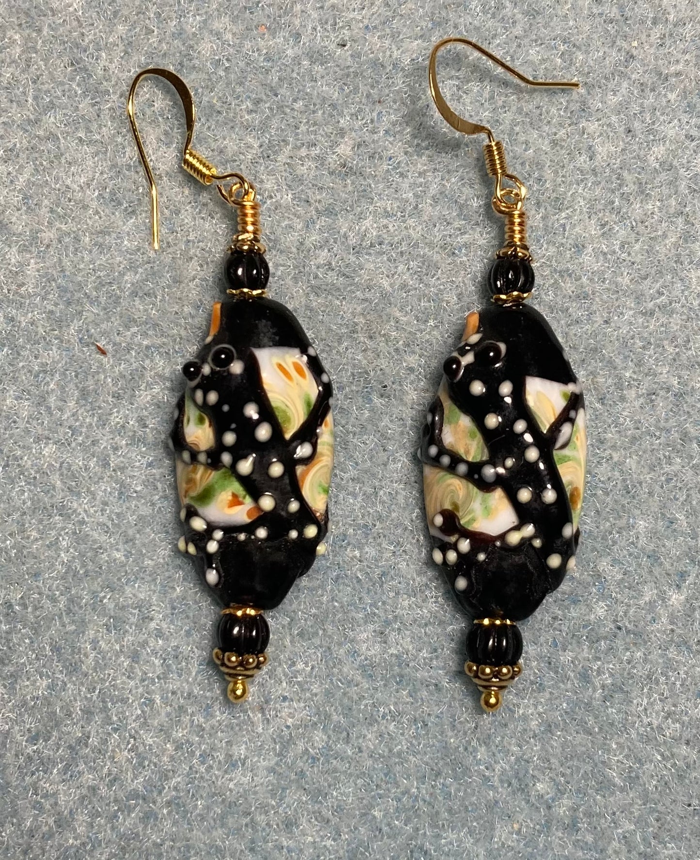 Black and yellow lamp work tiger salamander bead earrings adorned with black Czech glass beads.