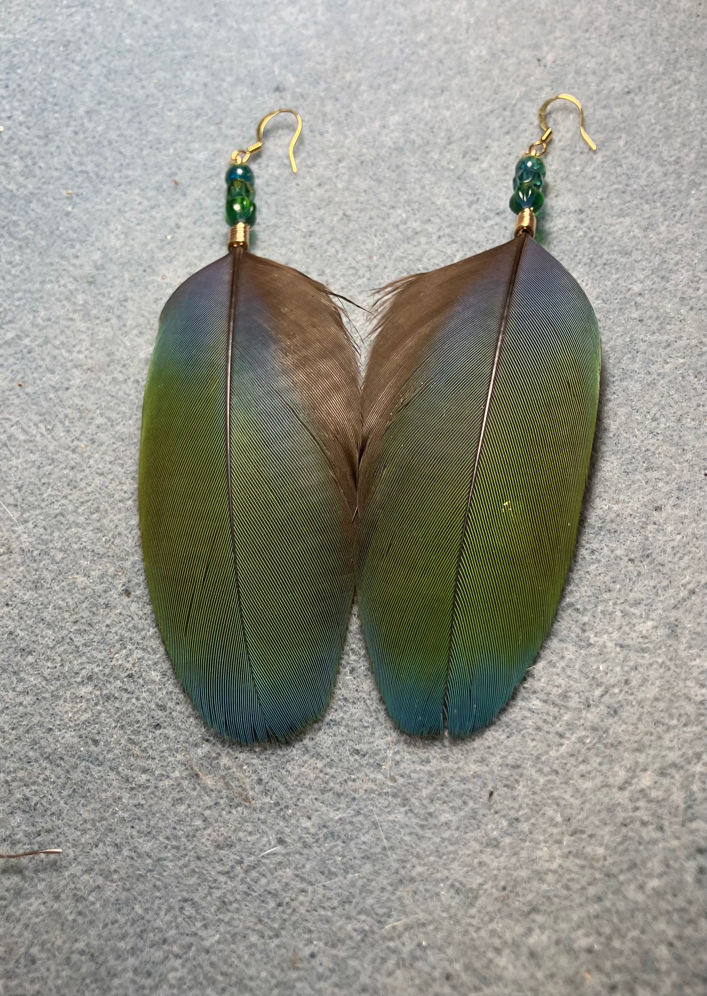 Blue and green scarlet macaw feather earrings adorned with blue green Czech glass beads.