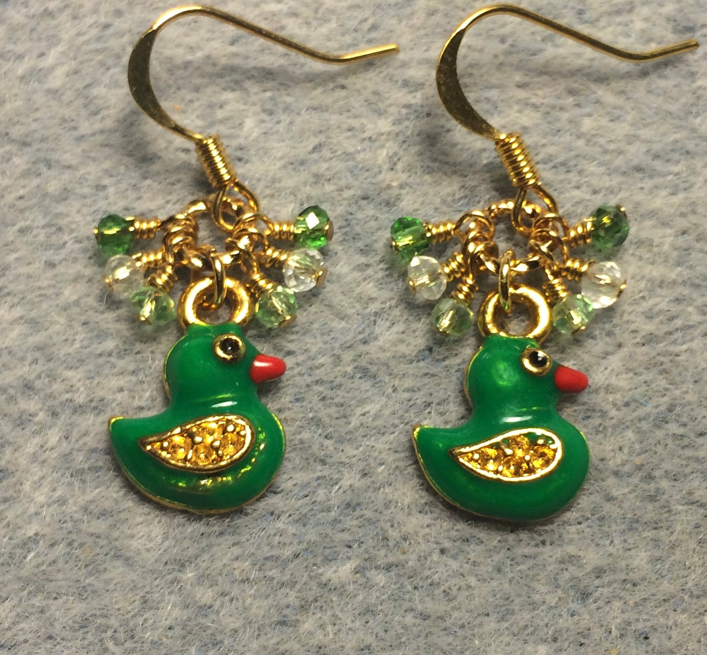 Small green enamel duck charm earrings adorned with tiny dangling green Chinese crystal beads.