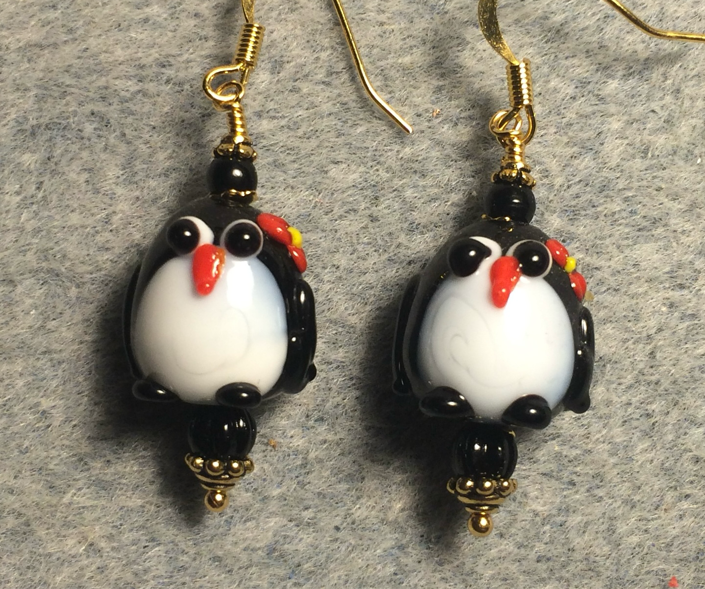 Black, white, and red lamp work penguin bead earrings adorned with black Czech glass beads.