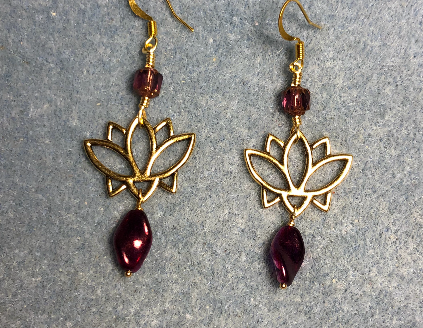 Gold lotus flower connector charm earrings adorned with metallic purple Czech glass twist beads and metallic purple Czech glass beads.