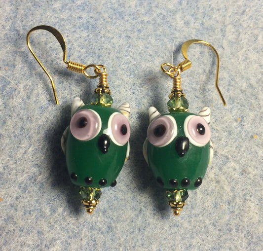 Dark green and lavender lamp work owl bead earrings adorned with green Chinese crystal beads.