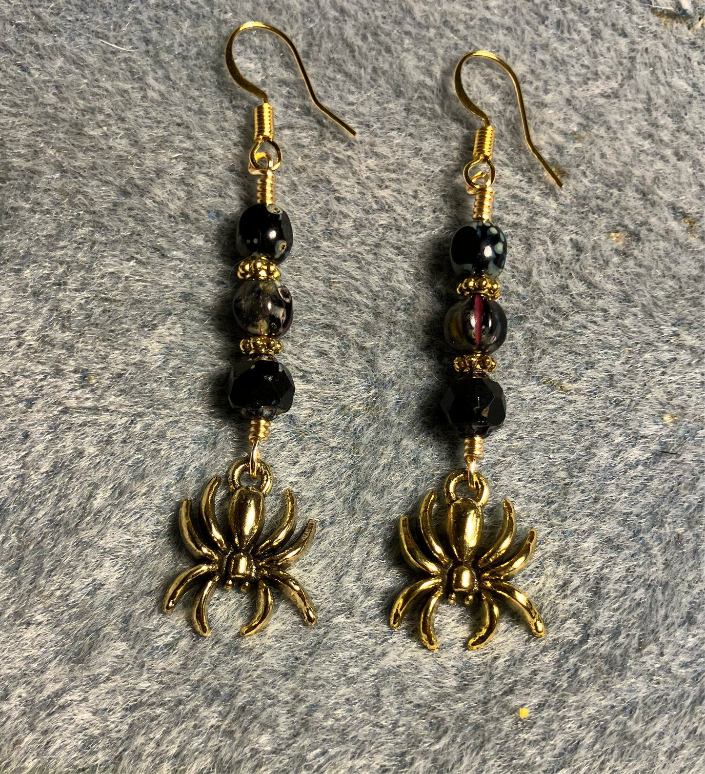 Gold spider charm earrings adorned with black Picasso Czech glass beads