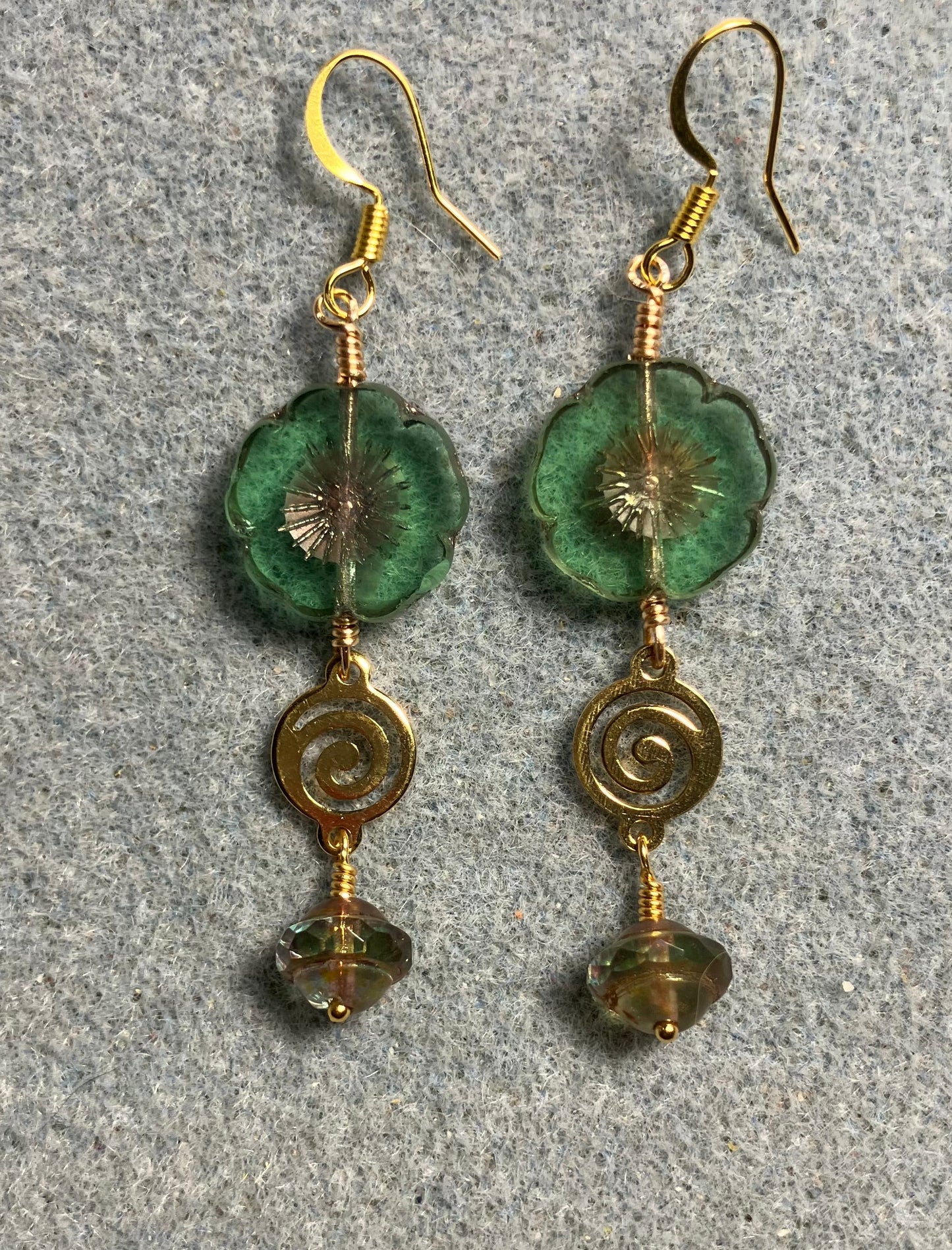 Green and gold Czech glass pansy bead earrings adorned with gold swirly connectors and green and gold Czech glass Saturn beads.