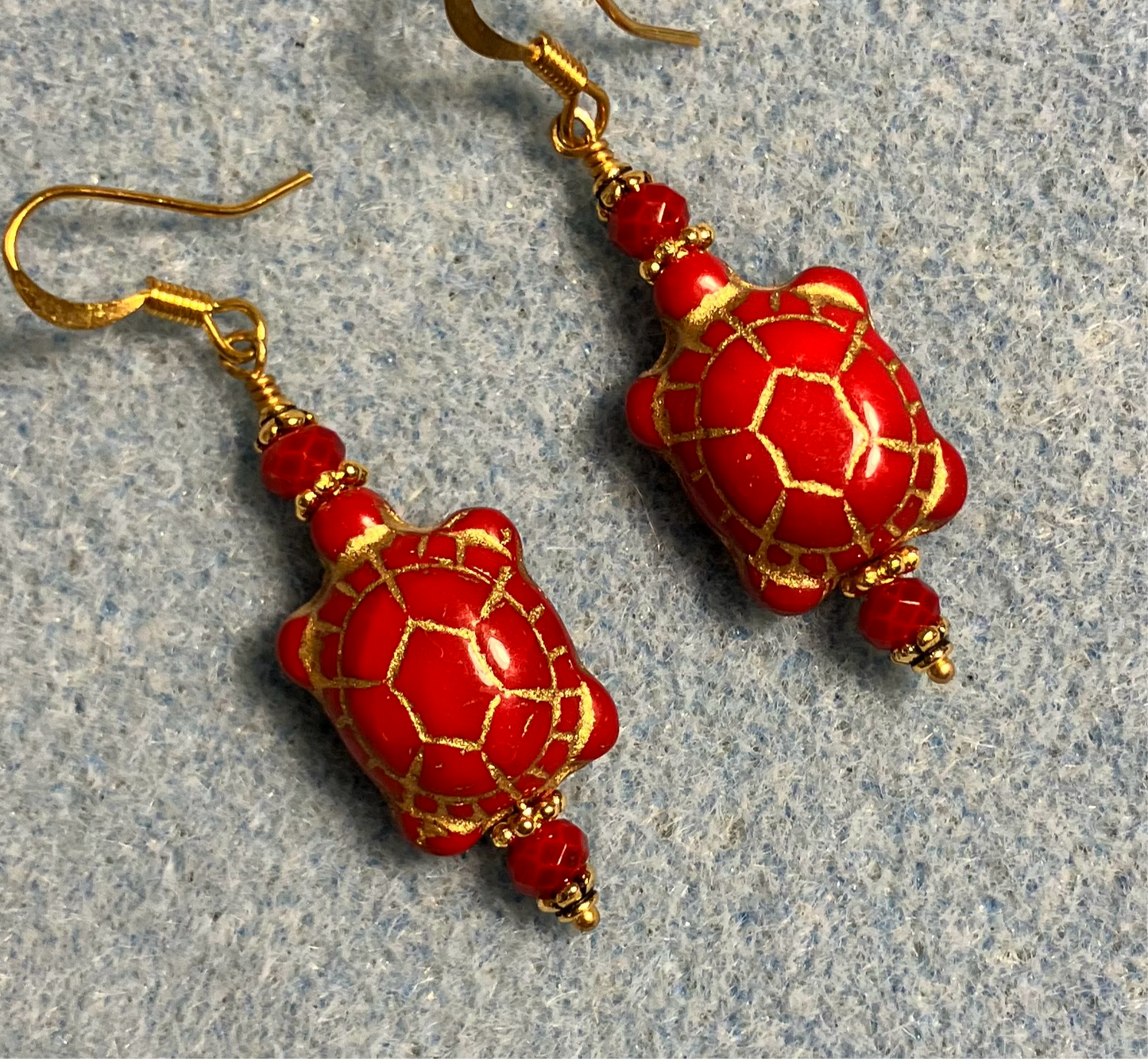 Opaque red (with gold inlay) Czech glass turtle bead earrings adorned with red Chinese crystal beads.