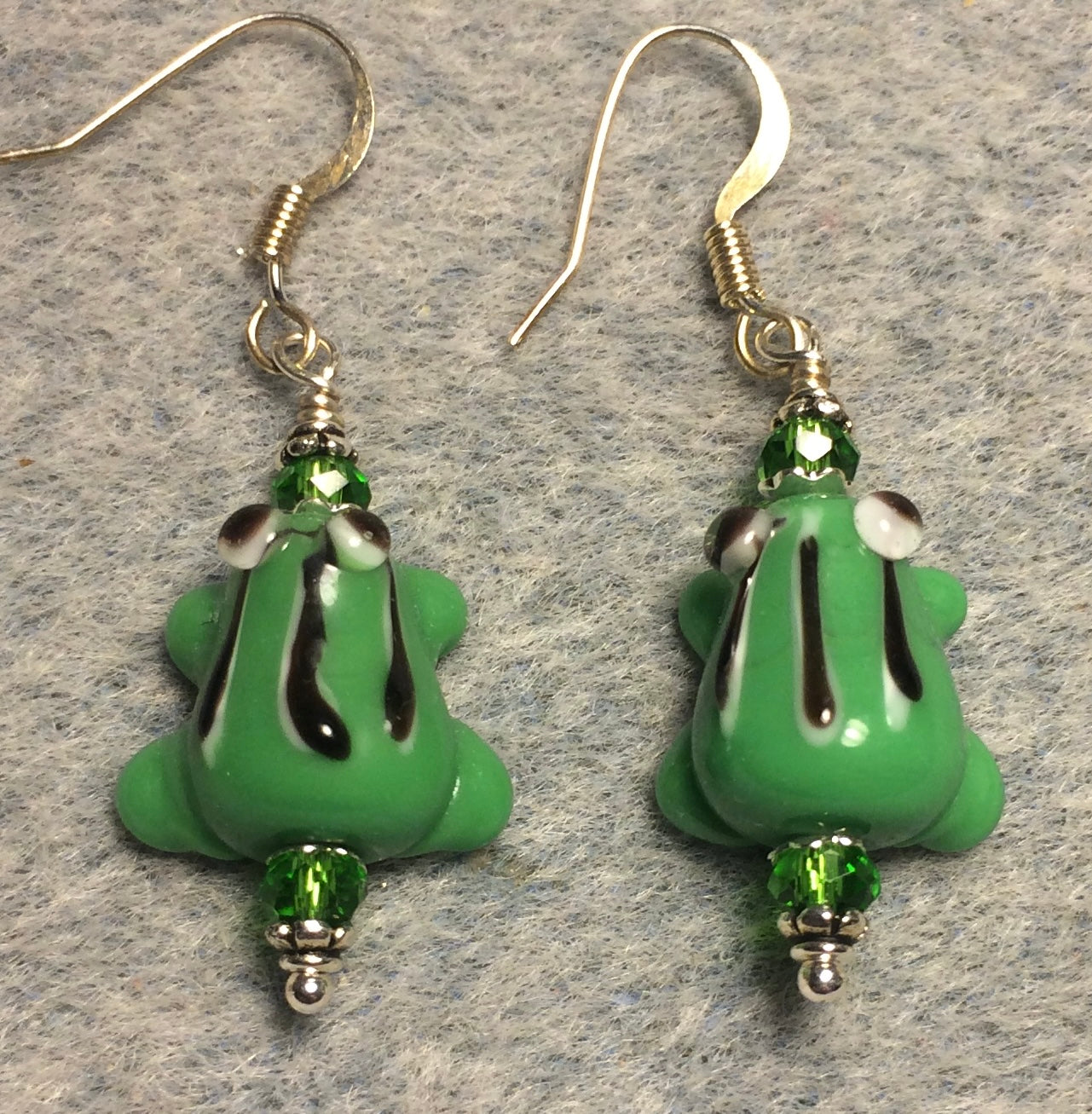 Small green with black stripes lamp work frog bead earrings adorned with green Chinese crystal beads.