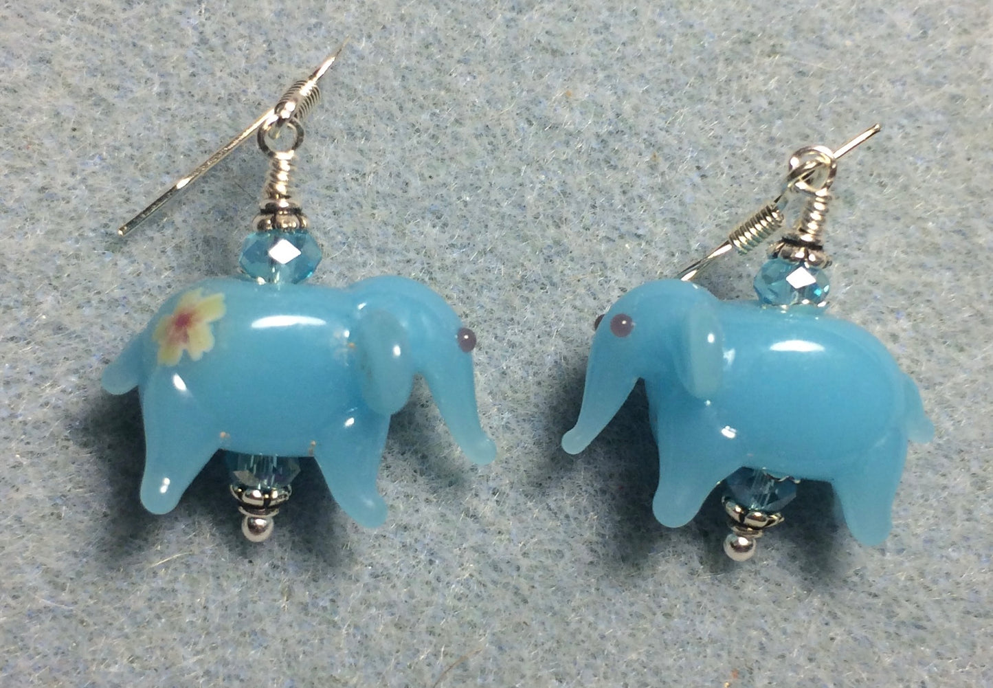 Opaque turquoise lamp work elephant bead earrings adorned with turquoise Chinese crystal beads.