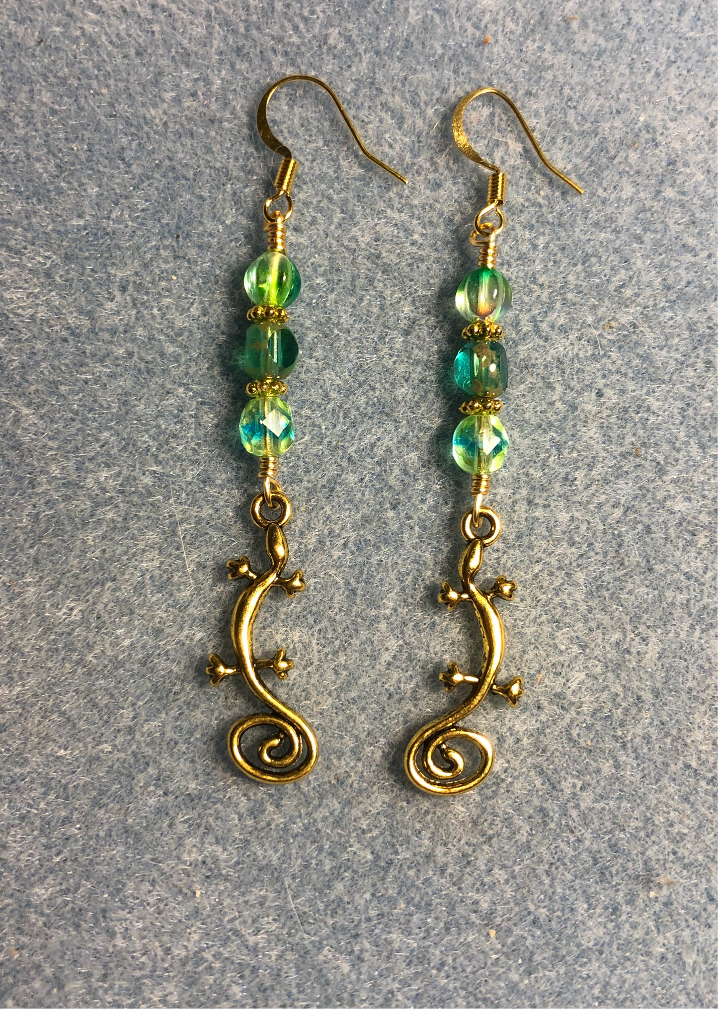Gold swirly tailed lizard charm earrings adorned with blue green Czech glass beads