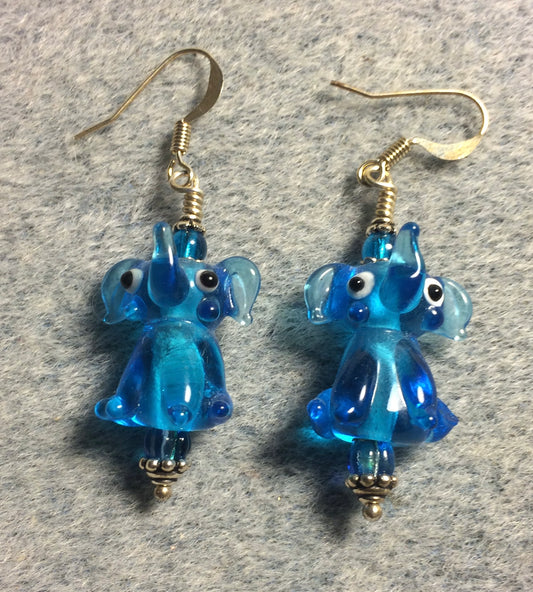 Translucent turquoise lamp work sitting elephant bead earrings adorned with turquoise Czech glass beads.