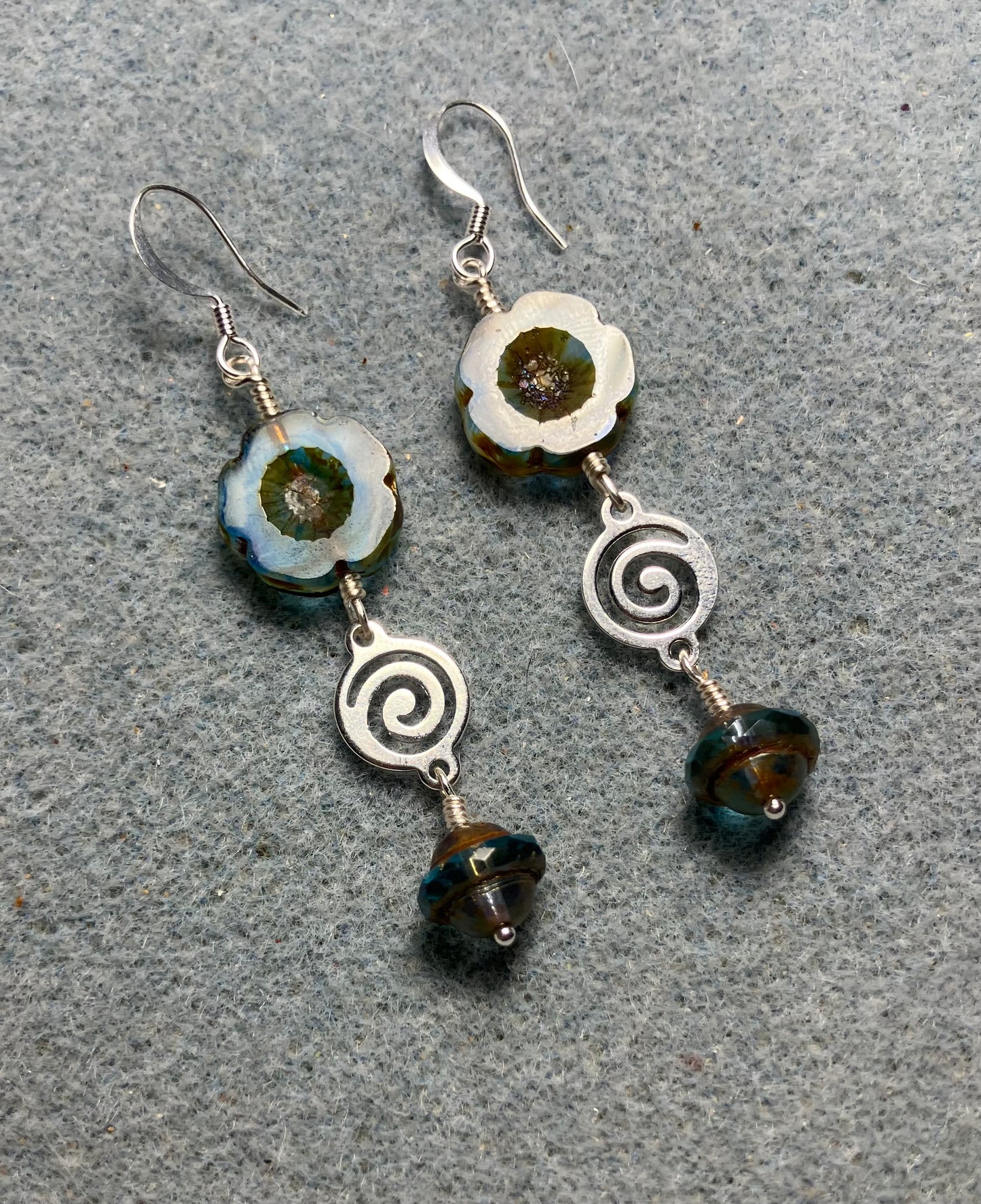 Blue striped Czech glass pansy bead earrings adorned with silver swirly connectors and blue Czech glass Saturn beads.