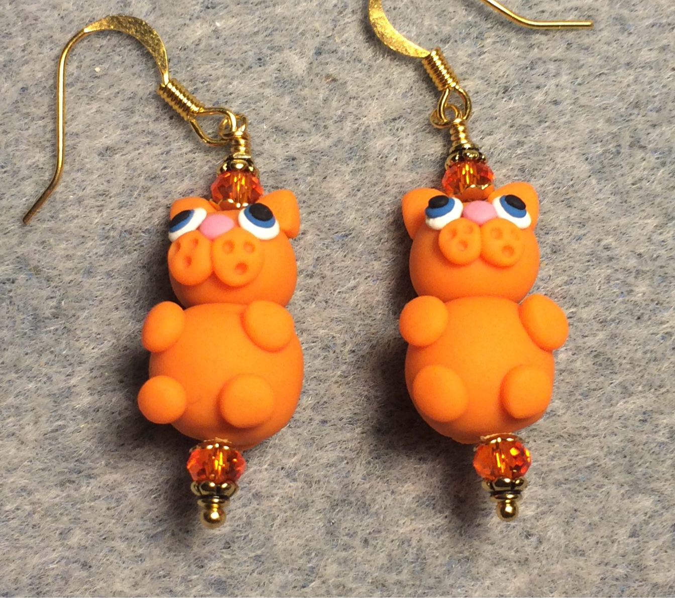 Orange polymer clay cat bead earrings adorned with orange Chinese crystal beads.