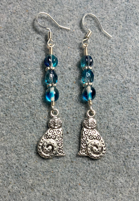 Silver swirly tailed cat charm earrings adorned with turquoise Czech glass beads