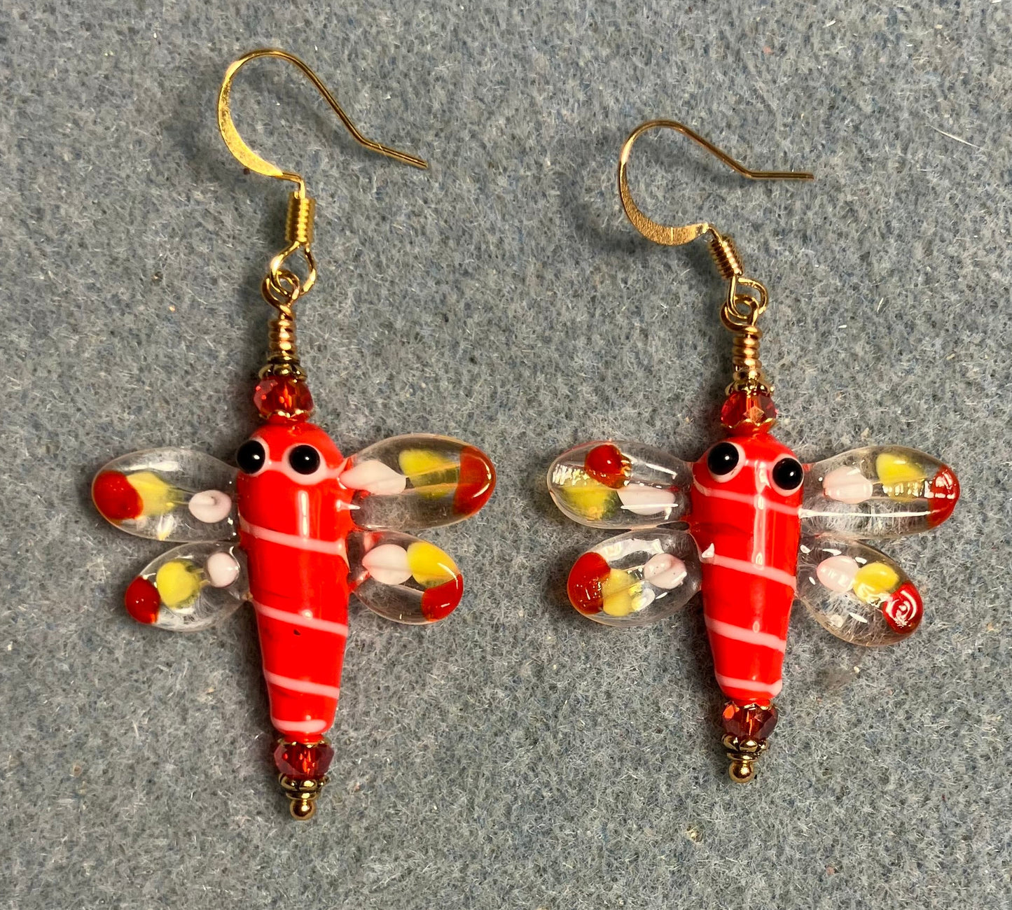 Red, white, and yellow lamp work dragonfly bead earrings adorned with red Chinese crystal beads.