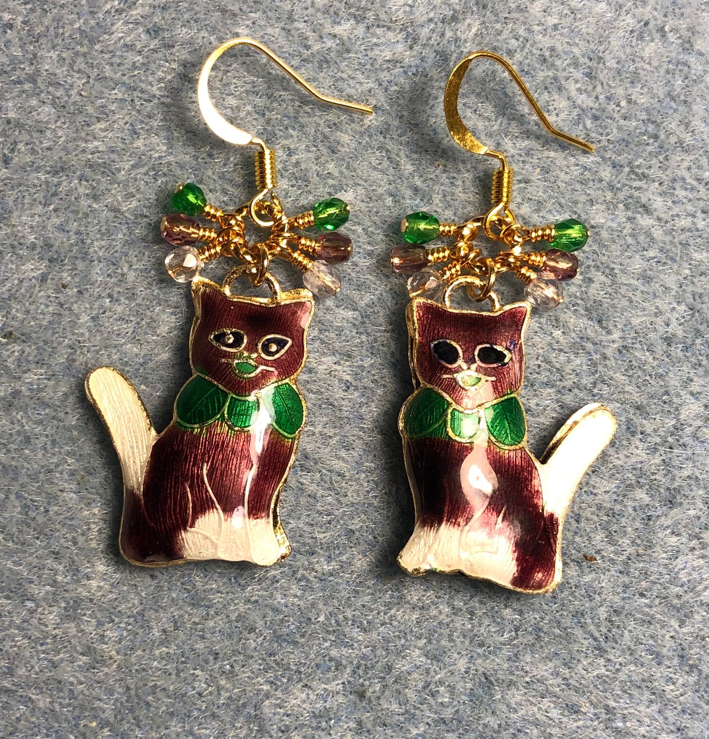 Purple, green, and white cloisonné cat charm earrings adorned with small dangling purple, green, and clear Czech glass beads.