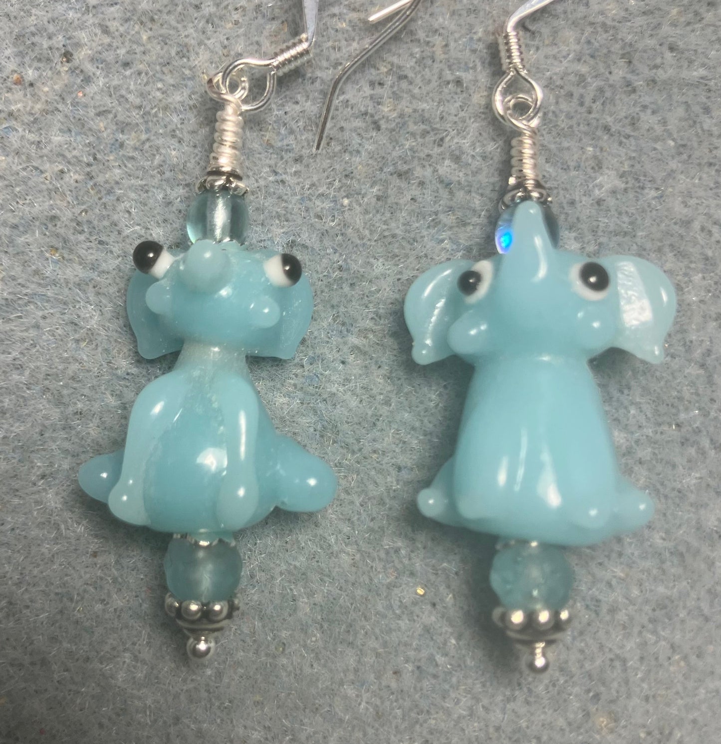 Opaque light aqua lamp work sitting elephant bead earrings adorned with light aqua Czech glass beads.