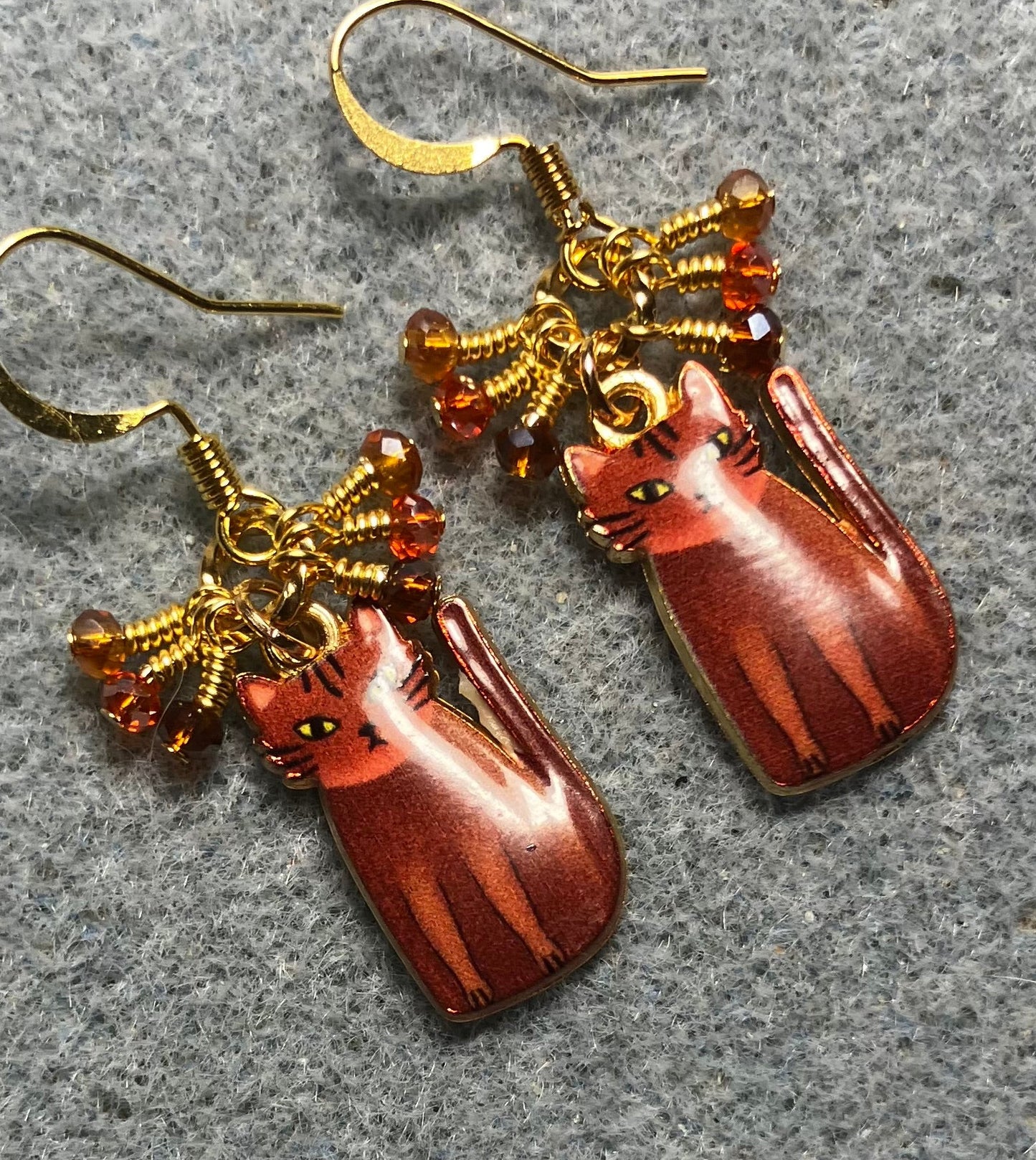 Brown, amber, and orange enamel cat charm earrings adorned with tiny dangling brown, amber, and orange Chinese crystal beads.