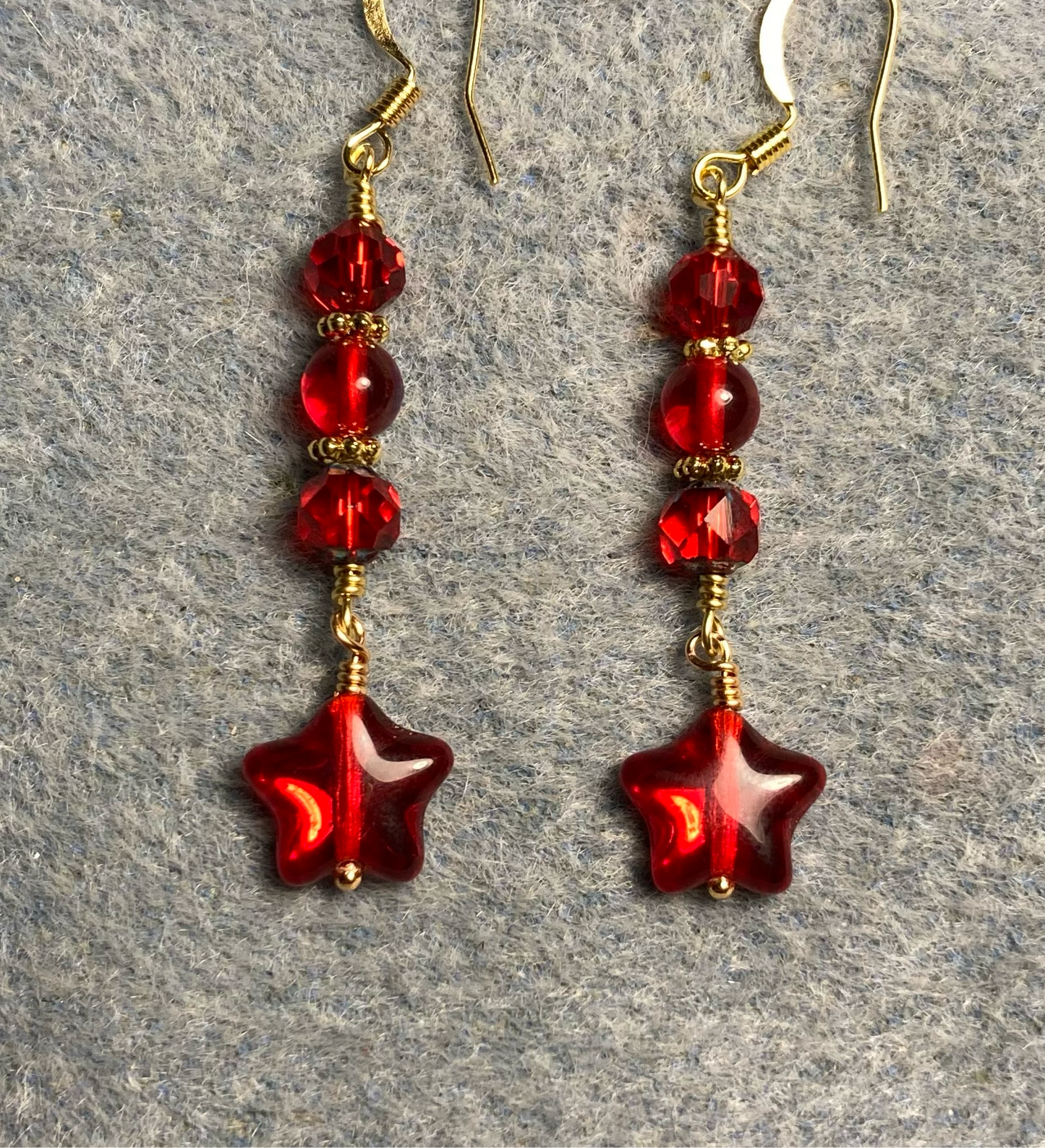 Small translucent red Czech glass star bead earrings adorned with red Czech glass beads.