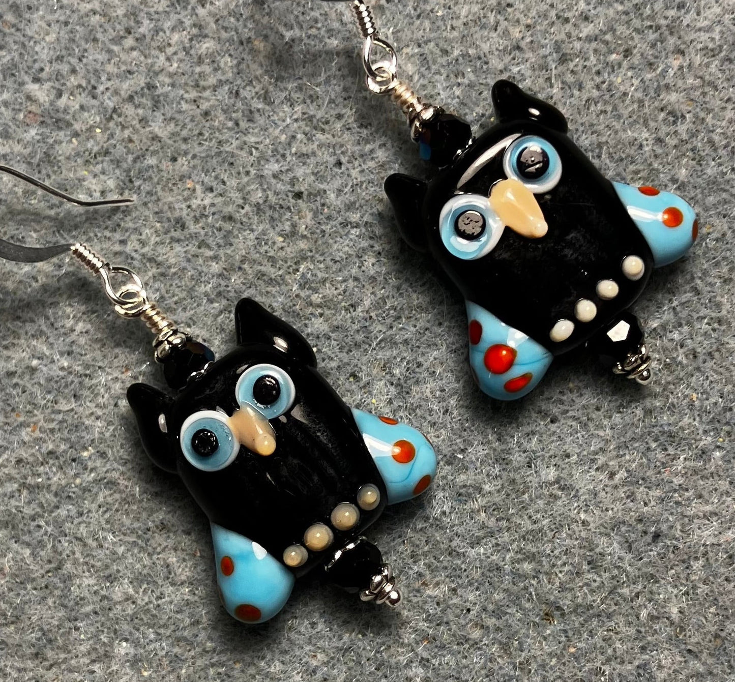 Black and blue lamp work owl bead earrings adorned with black Chinese crystal beads.