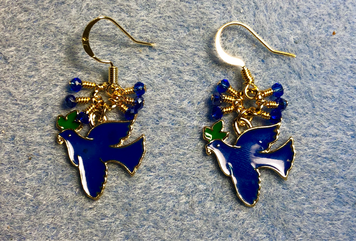 Dark blue, green, and gold enamel dove charm earrings adorned with tiny dangling dark blue Chinese crystal beads.