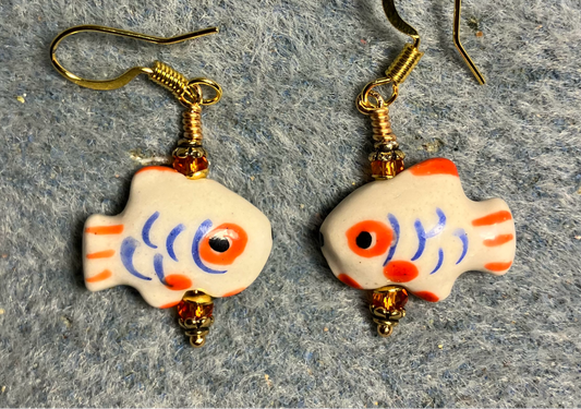 Small white, blue, and orange ceramic fish bead earrings adorned with orange Chinese crystal beads.