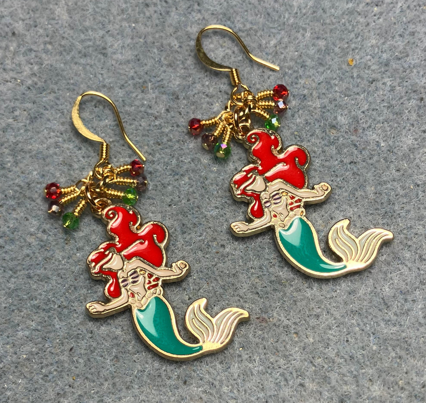 Red, green, and purple enamel mermaid charm earrings adorned with tiny dangling red, green, and purple Chinese crystal beads.