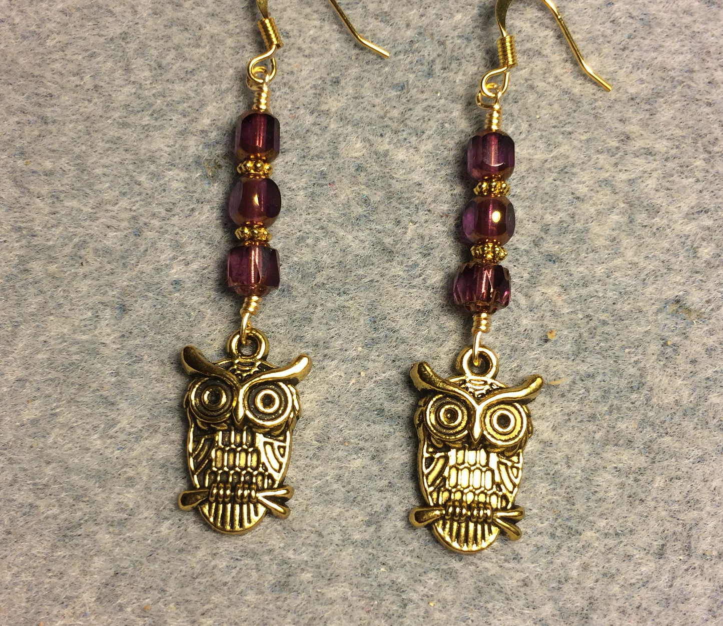 Gold owl charm earrings adorned with purple Czech glass beads