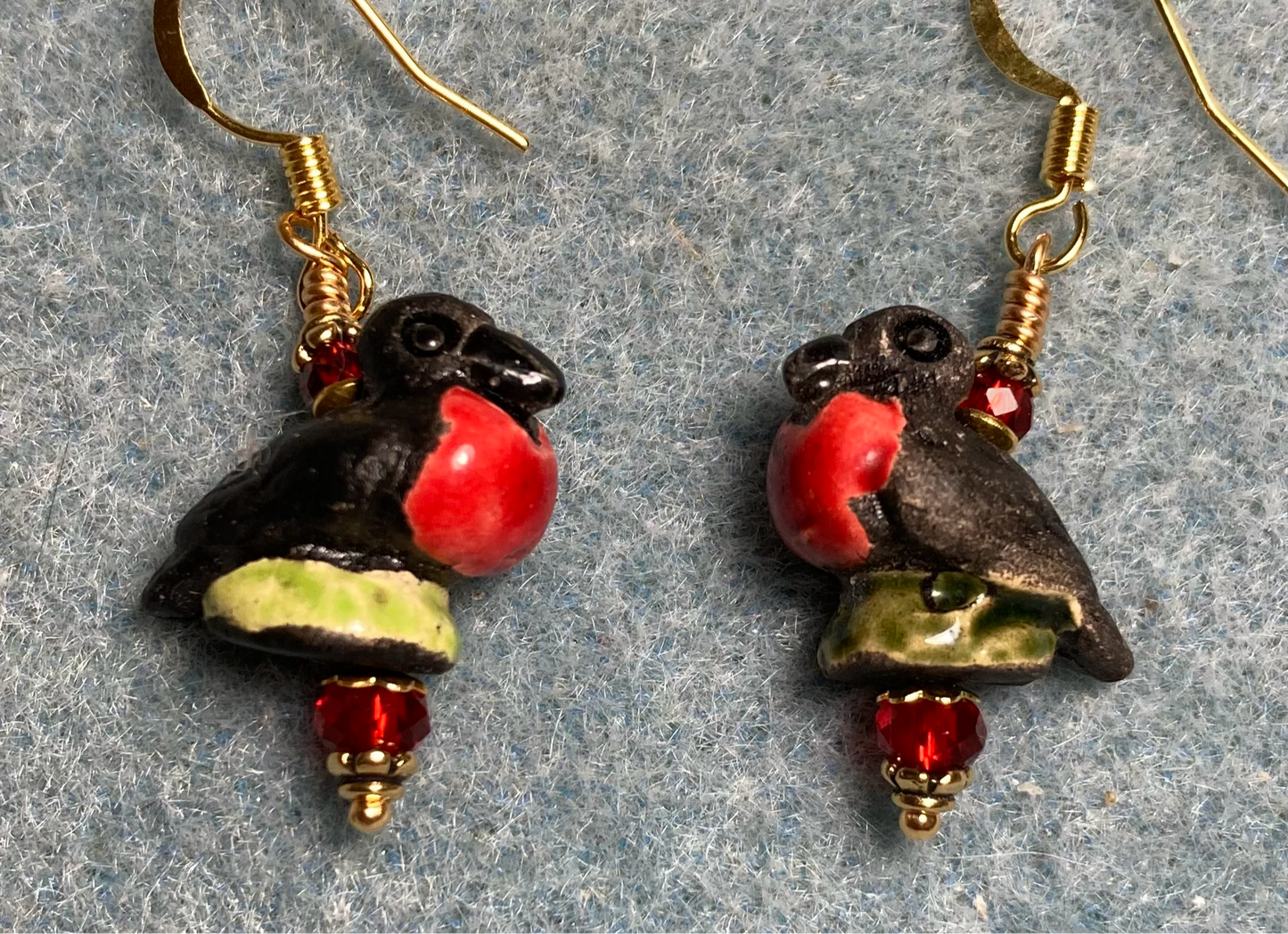 Small red and black ceramic frigate bird bead earrings adorned with red Chinese crystal beads.