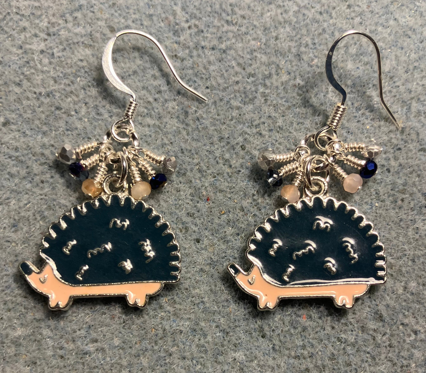 Dark blue and beige enamel hedgehog charm earrings adorned with tiny dangling dark blue, beige, and silver Chinese crystal beads.