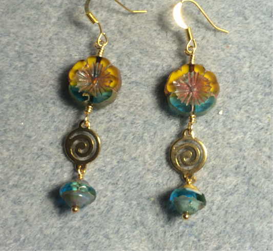 Turquoise and yellow Czech glass pansy bead earrings adorned with gold swirly connectors and turquoise Czech glass Saturn beads.