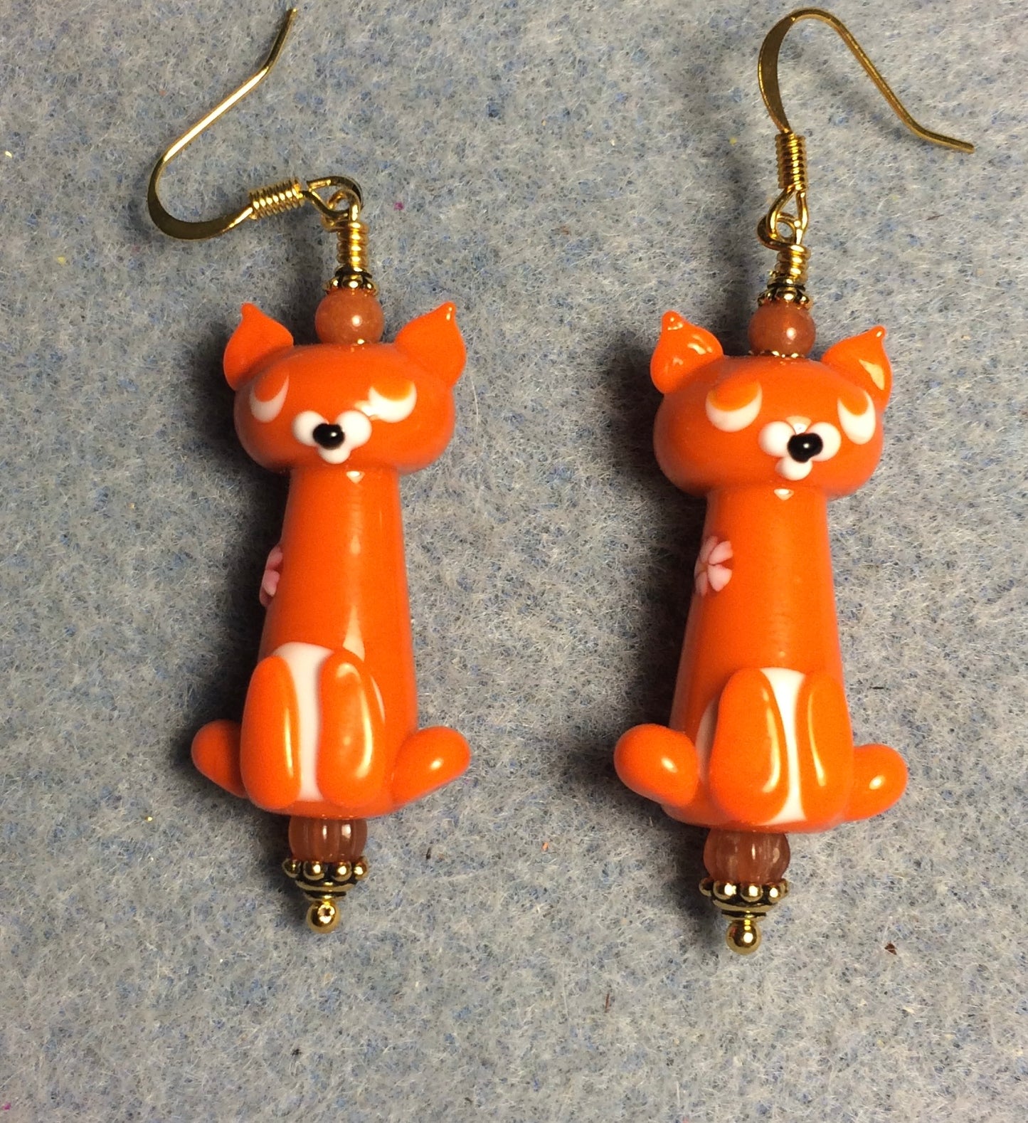 Opaque orange lamp work cat bead earrings adorned with orange Czech glass beads.