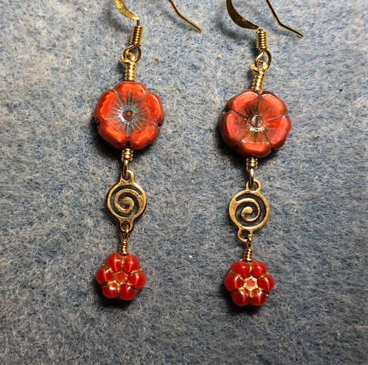 Orange Czech glass pansy bead earrings adorned with gold swirly connectors and tiny orange Czech glass daisy beads.