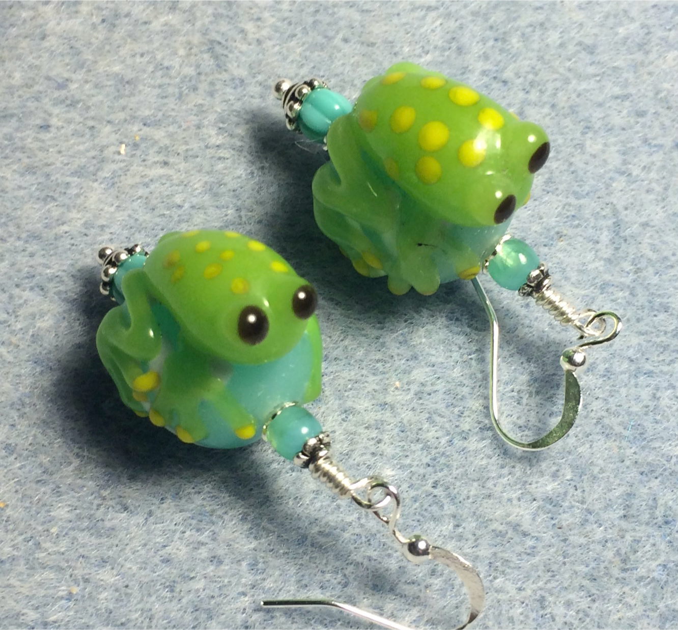 Turquoise and green lamp work frog bead earrings adorned with turquoise Czech glass beads.