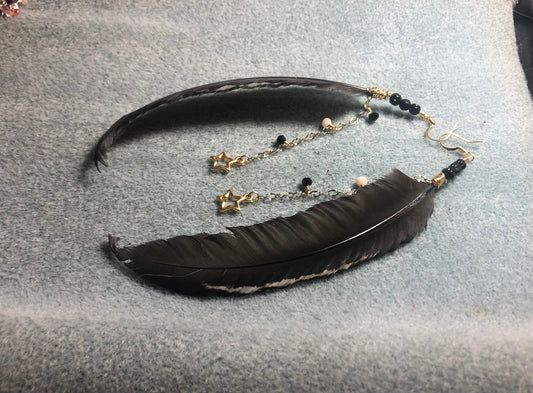 Long black chicken feather earrings adorned with black Czech glass beads and gold chain with gold star charms.