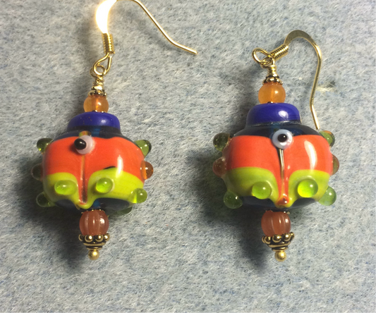 Orange, blue, and green lamp work fish bead earrings adorned with orange Czech glass beads.