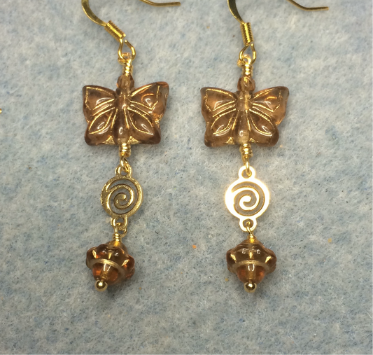 Brown Czech glass butterfly bead earrings adorned with gold swirly connectors and brown Czech glass Saturn beads.