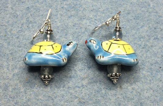 Blue and yellow ceramic turtle bead earrings adorned with light blue Czech glass beads.