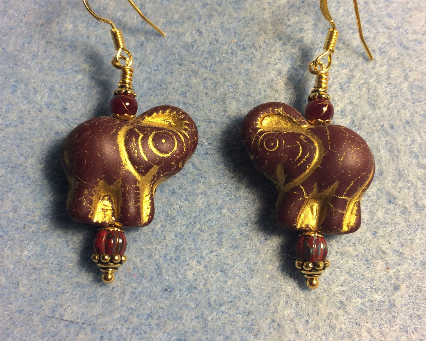 Dark red (with gold inlay) Czech glass elephant bead earrings adorned with dark red Czech glass beads.