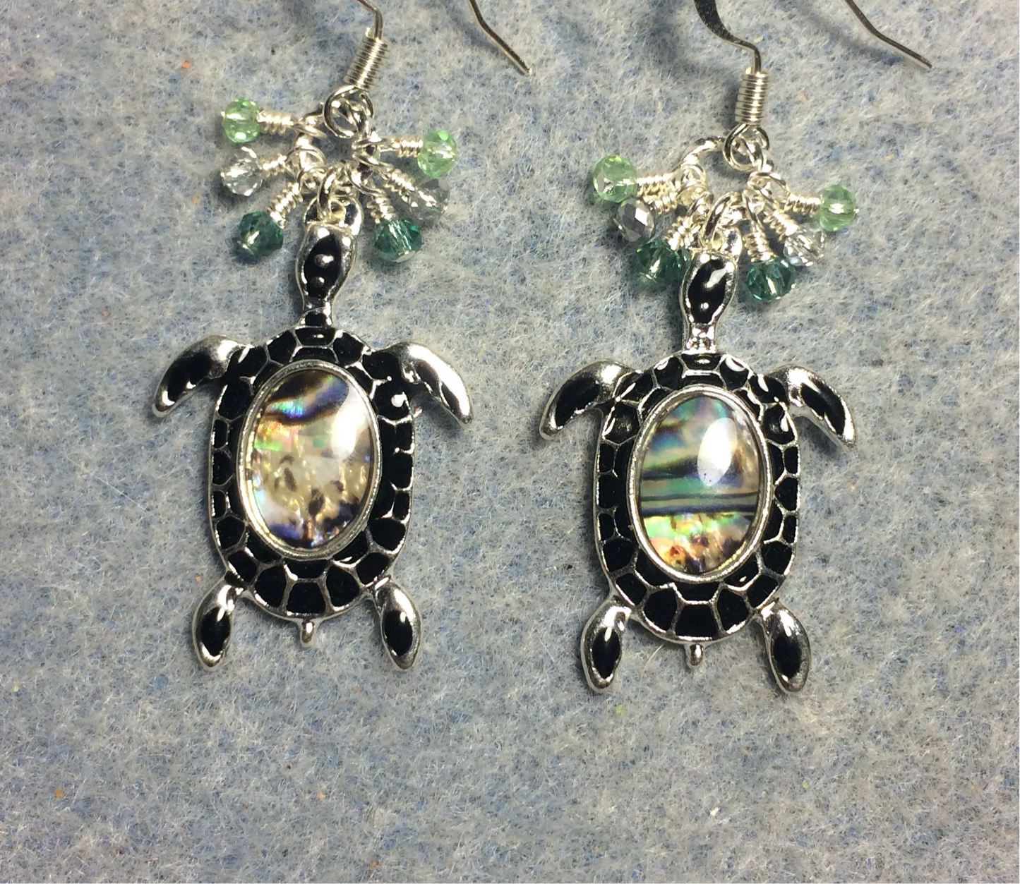 Silver and abalone turtle charm earrings adorned with small dangling light green and silver Chinese crystal beads.